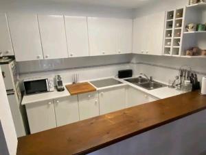 a kitchen with white cabinets and a sink at 2 habitacions, aire fred i calent, piscina, parking in Empuriabrava
