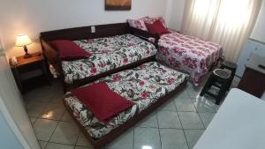 a small bedroom with two beds and a bed with a bed sqor at Flat 206 Hotel Cavalinho Branco (3 piscinas, elevador, sauna) in Águas de Lindoia