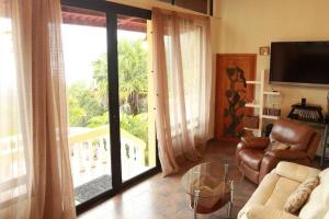 een woonkamer met een bank en een groot raam bij Hummingbird House Panama in Los Altos de Cerro Azul
