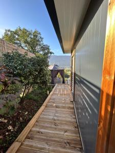 a wooden walkway leading up to a house at The Tiny home avec jacuzzi 5 min du lac du Bourget 10 min d Aix les bains et Chambery in Voglans