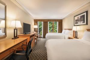 Habitación de hotel con 2 camas y escritorio en Holiday Inn & Suites North Vancouver, an IHG Hotel en North Vancouver