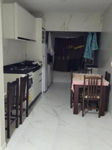 a kitchen with a table and a stove and a table and chairs at Novo Lar Itapema-2 in Itapema +4 photos