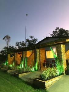 un edificio de ladrillo con luces verdes. en Chalés da Chapada en Carolina