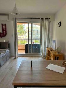 sala de estar con mesa y puerta corredera de cristal en pin rollan beach, en Saint-Mandrier-sur-Mer