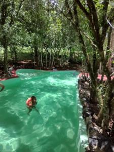 a person swimming in a pool in a river at Estancia La Paulina!!! 1 hora de las Cataratas!!! in Eldorado