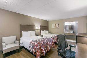una habitación de hotel con 2 camas y una silla en Red Roof Inn Baltimore, en Baltimore