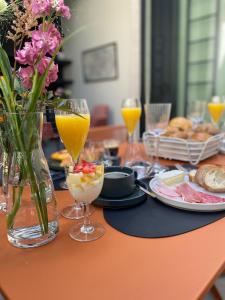 een tafel met borden en glazen sinaasappelsap bij Maison Brunon in Brugge