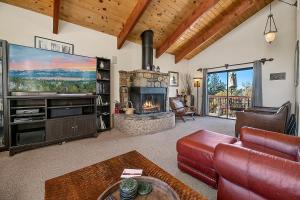 - un salon avec un canapé et une cheminée dans l'établissement King's Cabin - Spacious mountain home with picturesque views, fast internet!, à Big Bear Lake