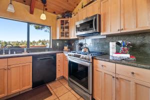 een keuken met houten kasten en een fornuis met oven bij King's Cabin - Spacious mountain home with picturesque views, fast internet! in Big Bear Lake