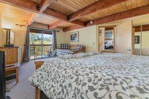 een slaapkamer met een groot bed en een balkon bij King's Cabin - Spacious mountain home with picturesque views, fast internet! in Big Bear Lake