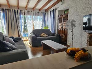 een woonkamer met een bank en een tafel bij Villa Las Adelfas (escapada ideal en Costa Blanca) in Calpe