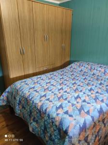 a bedroom with a bed and wooden cabinets at Estancia La Paulina!!! 1 hora de las Cataratas!!! in Eldorado