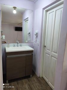 een badkamer met een wastafel en een grote spiegel bij Estancia La Paulina!!! 1 hora de las Cataratas!!! in Eldorado