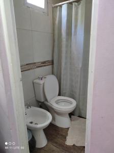 a bathroom with a toilet and a shower curtain at Estancia La Paulina!!! 1 hora de las Cataratas!!! in Eldorado