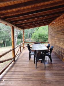 a wooden deck with a table and chairs on it at Estancia La Paulina!!! 1 hora de las Cataratas!!! in Eldorado
