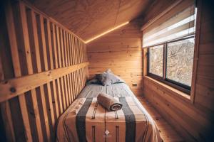 a small room with a bed in a wooden cabin at Yuki Yama in Malalcahuello