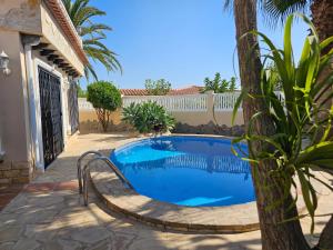 a swimming pool in a yard with a tree at Villa Las Adelfas (escapada ideal en Costa Blanca) in Calpe