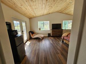 a large living room with a wooden ceiling at Hidden Falls Retreat in Oakhurst