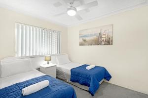 a bedroom with two beds and a painting on the wall at Oceanside Cove in Gold Coast