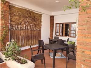 un comedor con mesas y sillas y un mural en la pared en Casa San Martin Suites, en Cochabamba