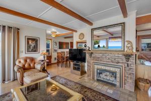 a living room with a fireplace and a tv at Whale Vista in Depoe Bay