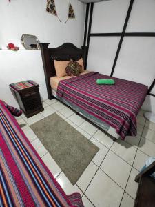 Dormitorio pequeño con cama y alfombra en Francisco's rest house hotel en Antigua Guatemala