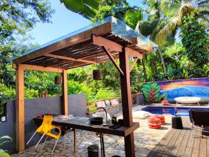 a patio with a table and chairs and a pool at Encantos da Ilha mais Bela - 150m das praias Viana e Siriúba in Ilhabela +19 photos