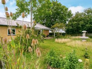 un jardín con un baño de aves y una casa en 6 person holiday home in Tranek r, en Tranekær