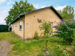 una pequeña casa de ladrillo en un patio con flores en 6 person holiday home in Tranek r, en Tranekær