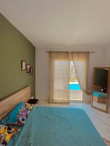 1 dormitorio con 1 cama grande y ventana grande en SHARM ENJOY APARTMENTS en Sharm El Sheikh