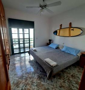 ロス・アブリゴスにあるTerrazas del Surのベッドルーム1室(壁にサーフボード付きのベッド1台付)