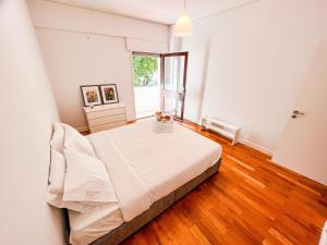 Seaside Elegance and Tranquility: Your Luxurious Porto Getaway في بورتو: غرفة نوم بيضاء بها سرير ونافذة