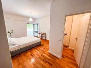 um quarto com uma cama e piso em madeira em Seaside Elegance and Tranquility: Your Luxurious Porto Getaway no Porto