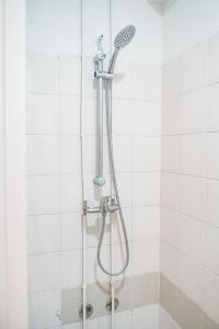 um chuveiro numa casa de banho em azulejos brancos em Seaside Elegance and Tranquility: Your Luxurious Porto Getaway em Porto