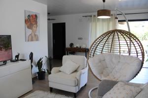 - un salon avec une chaise et une balançoire dans l'établissement Villa Perle - 2 suites, à Matoury