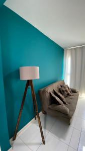 a living room with a couch and a lamp at Flat Muro Alto Porto de Galinhas in Porto De Galinhas