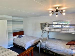 a bedroom with two bunk beds and a ceiling fan at Tranquil Retreat - Spacious Home for a Relaxing Getaway 