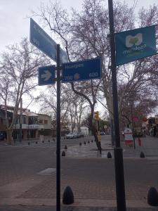 two blue street signs on a pole on a city street at Casa Huarpes in Mendoza