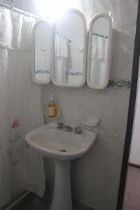 a bathroom with a sink and mirrors on the wall at Casa Huarpes in Mendoza