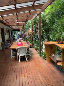 patio ze stołem i krzesłami na drewnianym tarasie w obiekcie Beautiful 2Bdr House with Pool w mieście Byron Bay