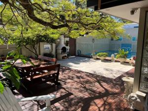 a patio with a bench and a table and a tree at Beautiful 2Bdr House with Pool in Byron Bay