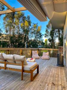 a wooden deck with a bench and pillows on it at Tranquil Retreat - Spacious Home for a Relaxing Getaway 