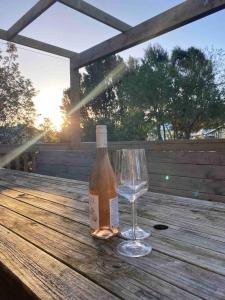 a bottle of wine and a wine glass on a wooden table at Tranquil Retreat - Spacious Home for a Relaxing Getaway 