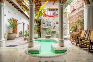 an indoor pool in a courtyard with columns at Casa Verde Hotel in Santa Marta