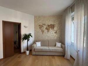 sala de estar con sofá y mapa en la pared en Appartamento Cassandra en Seregno