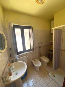 baño con lavabo y aseo y ventana en Salemi San Biagio townhouse in Sicily, en Salemi