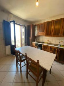 una cocina con mesa y 2 sillas. en Salemi San Biagio townhouse in Sicily, en Salemi