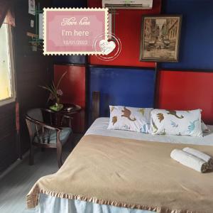 a bedroom with a bed and a sign that says im here monitored at Mykampung Chalet in Ipoh