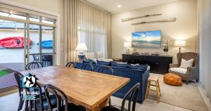 Una sala de estar con una mesa y un sofá azul. en Seaspray Cottage Holiday Accommodation Victor Harbor, en Victor Harbor