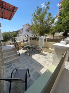 een terras met stoelen en een tafel op een balkon bij 1922 Historic House in Kavala